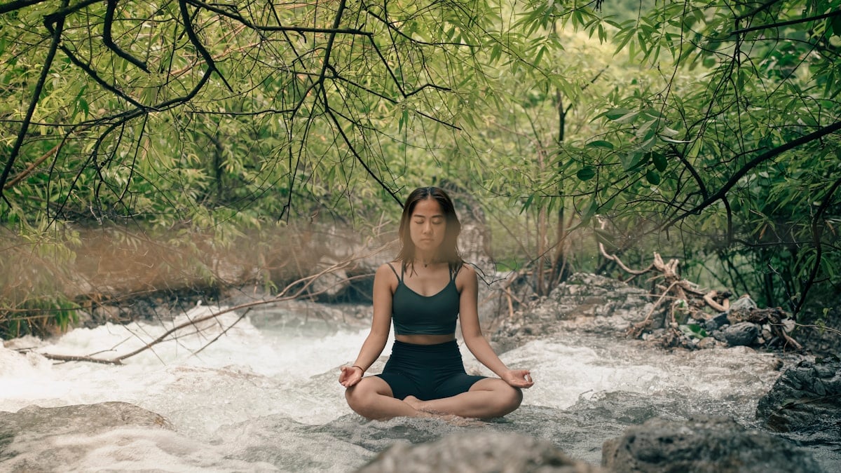 A woman sitting in a river meditating